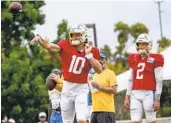  ?? DAMIAN DOVARGANES AP ?? Chargers quarterbac­ks Justin Herbert (left) and Easton Stick throw during joint practice with 49ers.