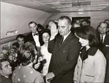  ?? Associated Press file photo ?? In this Nov. 22, 1963, photo, Lyndon B. Johnson is sworn in as president as Jacqueline Kennedy stands at his side in the cabin of the presidenti­al plane on the ground at Love Field in Dallas. Kennedy declined to change her blood-stained pink dress even at the hurriedly arranged swearing in.