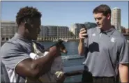  ?? RICK RYCROFT — THE ASSOCIATED PRESS ?? In this file photo, Rice NCAA college football players Nashon Ellerbe, left, holds an Eastern Gray kangaroo joey named Tabby as teammate Jack Fox takes a picture, in Sydney, Australia. The Rice football team was about 8,500 miles from their Houston...
