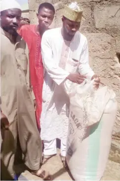  ??  ?? Leader of the group, Ahmad Sarkin Yaki Yauri displaying millet already counted into a 100kg bag