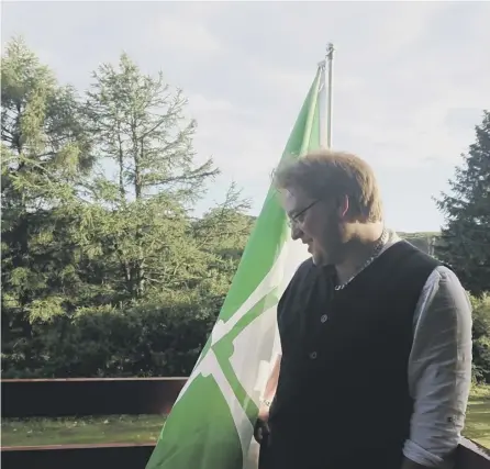  ??  ?? 0 Philip Tibbets, pictured standing with the flag of Kirkcudbri­ghtshire, is Scotland’s first honorary vexillolog­ist