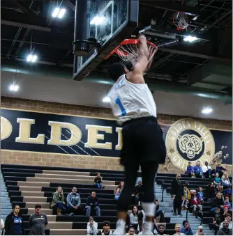  ?? Gilbert Bernal/The Signal ?? (Above) A participan­t in the half-time dunk contest attempts an acrobatic slam dunk at the Pro All-Star game benefittin­g Saugus High School at Golden Valley High School on Sunday. (Below) Guest judges watch as a basketball player dunks over a volunteer at the pro basketball All-Star game at Golden Valley High School.