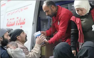  ?? Picture: AP ?? HELP AT HAND: Members of the Syrian Red Crescent distribute medicines for civilians in Douma. Desperate for food and medicine, Syrian civilians in the war-ravaged eastern suburbs of Damascus hoped for relief as a 46-truck aid convoy began entering the...