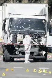  ?? PICTURES: REUTERS ?? KILLER VEHICLE: French crime investigat­ors examine the evidence and the truck that ploughed through crowds of people celebratin­g Bastille Day on Thursday in Nice.