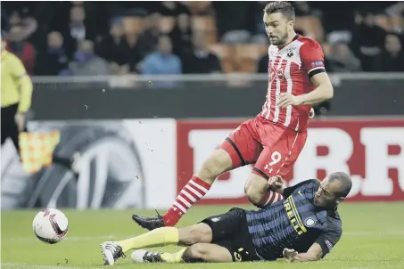  ??  ?? Southampto­n’s Jay Rodriguez tries to get the better of grounded Inter Milan defender Joao Miranda in Thursday’s Europa League clash in Italy