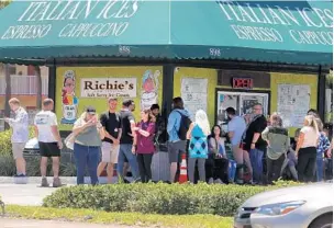  ?? CARLINE JEAN/SOUTH FLORIDA SUN SENTINEL ?? A group of people gather outside Richie’s Gourmet Italian Ices in Oakland Park.