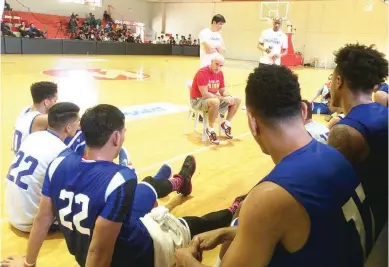  ??  ?? Gilas Pilipinas coach Tab Baldwin talks with members of the national team pool after a recent practice session at the Meralco gym. The team remains in high spirit the pull out of three players from the pool due to injuries. (Waylon Galvez)