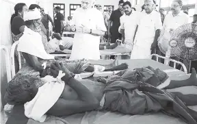  ?? AP ?? Indian Prime Minister Narendra Modi (centre), visits the injured victims at the Kollam district hospital after a massive fire broke out during a fireworks display at the Puttingal temple complex.