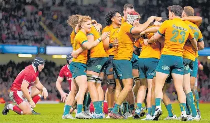  ?? Photo / AP ?? Australian players celebrate after the final whistle of their game against Wales in Cardiff.