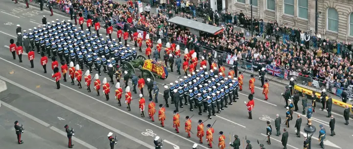  ?? ?? Scale and splendour: Sailors march at 75 paces per minute as they haul the coffin, draped in the Royal Standard, on the State Gun Carriage