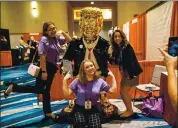  ?? ERIN SCHAFF — THE NEW YORK TIMES ?? From left: Analeeza Martinez, Haile Mokrzycki, and Sara Smith pose for a photo in front of a metal replica of former President Donald Trump.