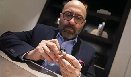  ?? MATT STONE PHOTOS / HERALD STAFF ?? Antoine Abeddy, owner of Date & Time jewelry, checks out a ring in his Sudbury store.