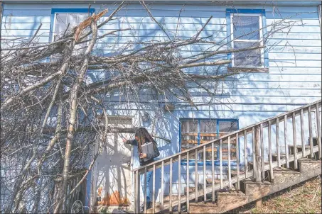  ?? (AP/David Goldman) ?? Larrecsa Cox knocks on the door of a home with tree damage from a recent storm as she checks on a client in Huntington, W.Va.