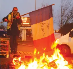  ?? (Pascal Rossignol/Reuters) ?? A ‘YELLOW VEST’ PROTESTER burns a flag yesterday at the approach to the A2 Paris-Brussels Motorway in Fontaine-Notre-Dame, France.