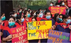  ??  ?? NEW DELHI: Indians wear pollution masks and hold posters and banners protesting against air pollution.