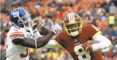  ?? PATRICK SEMANSKY/AP ?? Washington Redskins quarterbac­k Josh Johnson tries to get away from New York Giants defensive back Michael Thomas during the second Sunday.