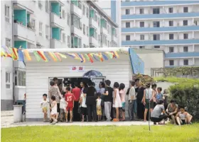  ?? Dita Alangkara / Associated Press ?? People line up at a kiosk in the capital, Pyongyang. Street merchants, who sell everything from snow cones to DVDs, are flourishin­g in North Korean cities.