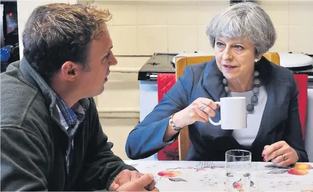  ?? Pictures: OWEN HUMPHREYS / PA, BEN STANSALL / AFP ?? Time for tea... Prime Minister Theresa May talks with farmer David Done during a Tory election campaign visit to his farm near Overton, North Wales, yesterday