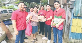  ?? ?? Loi (right), Terrance (left) and the rest of the Warisan Kota Kinabalu team delivering the aid to the woman in Inanam.