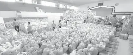  ??  ?? The Mandaue City government prepares relief goods for distributi­on to families affected by the COVID-19 pandemic. JOY TORREJOS