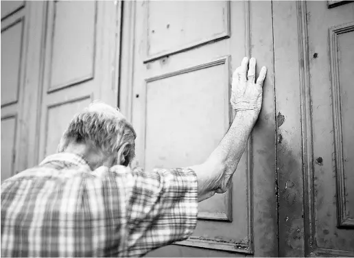  ?? Christophe­r Furlong / Gett y Imag es ?? A senior citizen leans against the door of a closed bank in Athens.