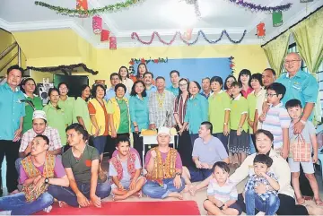  ??  ?? Tiang (standing, eighth left) with guests, special needs children and their parents pose for a group photo during PDK Kapit’s ‘5-in-1 Festive Party’ event-cum-open day.