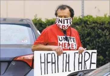  ?? Myung J. Chun Los Angeles Times ?? JOSE LUIS ACOSTA, who lost his hotel job in March, participat­es in a car caravan around hotels on Century Boulevard near Los Angeles Internatio­nal Airport to demand healthcare coverage during the pandemic.