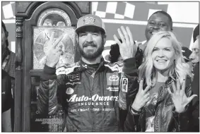  ?? AP/STEVE HELBER ?? Martin Truex Jr. (left) and his girlfriend Sherry Pollex (right) pose with the trophy as he celebrates after winning a NASCAR Cup Series race at Martinsvil­le Speedway in Martinsvil­le, Va., on Sunday.