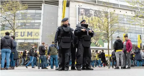  ??  ?? Hochsicher­heitsspiel: Vor dem Dortmunder Stadion bestimmten am Tag nach dem Anschlag schwer bewaffnete Polizisten das Bild.