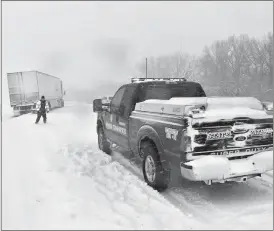  ?? NSP ?? Above, the Nebraska Sgtate Patrol assists a trucker whose rig went off the road during Monday’s snowstorm. On Monday, the NSP responded to more than 300 weather related incidents.