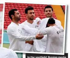  ?? AFP/GETTY IMAGES ?? In the spotlight: Russian media highlighte­d this picture, taken on Friday, showing three team-mates helping the injured Salah put on a top in training