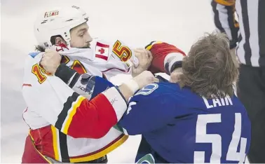  ?? GERRY KAHRMANN/Postmedia News ?? Calgary’s Kevin Westgarth, left, and Vancouver’s Kellan Lain fight two seconds into Saturday’s NHL game.