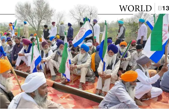  ?? NARINDER NANU/AGENCE FRANCE-PRESSE ?? FARMERS block railway tracks during a protest to demand minimum crop prices near a railway station on the outskirts of Amritsar, India. Thousands of Indian farmers are demanding a law to fix a minimum price for their crops, in addition to other concession­s including the waiving of loans.