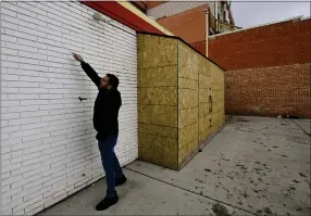  ?? ?? Owner Joe Barmada points out a crack forming in the back wall of the Winchell’s Donut House in Longmont on Wednesday. A vehicle struck the back wall causing significan­t damage and requiring a temporary structure, seen to the right, to be built to secure the building.