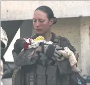  ?? U.S. DEPARTMENT OF DEFENSE VIA AP ?? Sgt. Nicole Gee holding a baby at Hamid Karzai Internatio­nal Airport in Kabul, Afghanista­n. Officials said Saturday that Gee was one of 13 U.S. troops killed in Thursday’s bombing in Kabul.