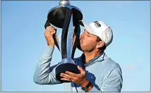  ?? ALASTAIR GRANT / AP ?? Charles Schwartzel of South Africa kisses the trophy as he poses for the media after he won the inaugural LIV Golf Invitation­al at the Centurion Club in St. Albans, England, on Saturday.