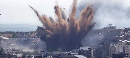  ?? / AP ?? CHAOS AT GAZA. Smoke rises following Israeli airstrikes on a building in Gaza City, Thursday, May 13, 2021. Weary Palestinia­ns are somberly marking the end of the Muslim holy month of Ramadan, as Hamas and Israel traded more rockets and airstrikes and Jewish-Arab violence raged across Israel.