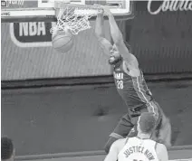  ?? MARK J. TERRILL/AP ?? The Heat’s Andre Iguodala dunks in front of the Bucks’ Brook Lopez on Tuesday during Game 5 of their Eastern Conference playoff series.