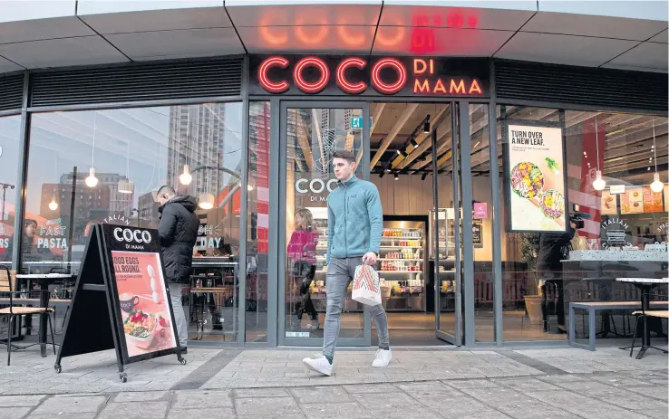  ?? PHOTOS BY AFP ?? A Karma app user collects his food from a Coco di Mama food outlet in London.