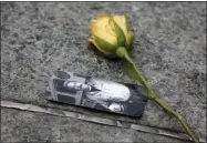  ?? SETH WENIG—ASSOCIATED PRESS ?? In this May 30, 2019 file photo, a rose rests next to a photograph of New York City Fire Department Lt. Steven Reisman in the 9/11 Memorial Glade near the National September 11Memorial & Museum. Reisman searched through the World Trade Center debris for remains, and then died in 2014of brain cancer at age 54.