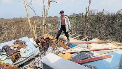  ?? (AP) ?? Pena. José Trinidad camina sobre lo que queda de su casa en Montebello, Puerto Rico, después del huracán.