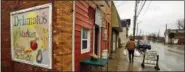  ?? GENE J. PUSKAR — THE ASSOCIATED PRESS ?? On March 1, a customer leaves Dylamatos Market owned by Dianne Shenk in Hazelwood, Pa.