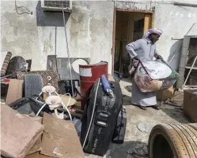  ??  ?? Mubarak Sultan gets on with the unhappy task of packing up and sorting out damaged belongings as he tries to rescue some of the items at his flooded family home in Al Ghurfa area of Fujairah city