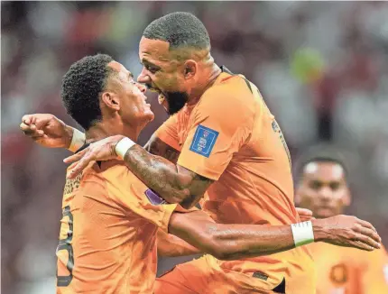  ?? MOISES CASTILLO/AP ?? Cody Gakpo of the Netherland­s, left, celebrates after scoring his side’s opening goal during the World Cup group A match against Qatar.