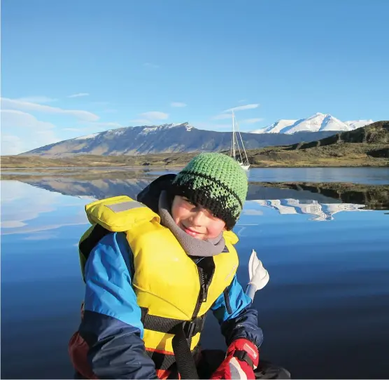  ??  ?? In Puerto Consuelo, Elias, 8, finds it’s just like sailing in Colorado, only with salt water, flamingos and bigger mountains. Opposite, farther south, clearing snow is often a necessity; Eric, 5, lugs trash bags up the Puerto Natales fishermen’s dock; a crab feast awaits.