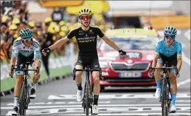  ?? THIBAULT CAMUS / ASSOCIATED PRESS ?? Britain’s Simon Yates (center), surrounded by Spain’s Pello Bilbao Lopez De Armentia (right) and Austria’s Gregor Muhlberger, celebrates as he crosses the finish line to win the 12th stage of the Tour de France on Thursday.