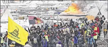  ?? THE BISMARCK TRIBUNE ?? A fire set by protesters burns as opponents of the Dakota Access pipeline leave their main protest camp Feb. 22 near Cannon Ball, N.D. A federal judge is hearing arguments about whether to stop the final bit of constructi­on on the pipeline.