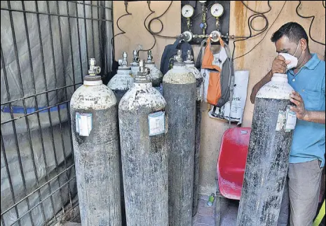  ?? PRAFUL GANGURDE/HT PHOTO ?? A hospital staff arranges oxygen cylinders outside the Covid ward at Thane Civil Hospital in Thane on Friday.