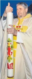 ?? FOTO: KURT GLÜCKLER ?? Pfarrer Robert Aubele entzündet die Osterkerze in der Osternacht am Osterfeuer.