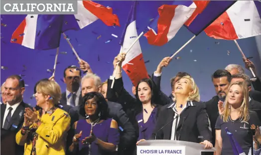  ?? Valery Hache / AFP / Getty Images ?? Supporters applaud far-right French presidenti­al candidate Marine Le Pen (at podium) at a campaign event Thursday.